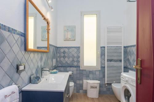 a blue and white bathroom with a sink and a toilet at Maison Chloe 2 in La Maddalena