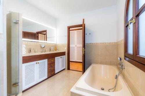 a bathroom with a tub and a sink at Villa Font de sa Cala in Font de Sa Cala