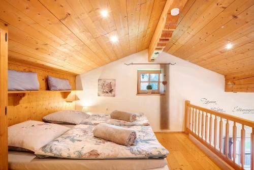 a bed in a room with a wooden ceiling at Ferienwohnung Rauschberg in Ruhpolding