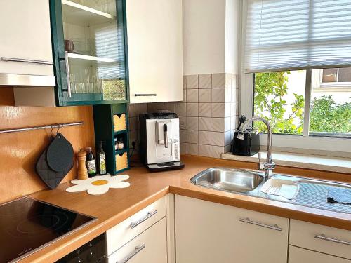 a kitchen with a sink and a microwave at Lichte Wohnung zum Wohlfühlen in Bastheim