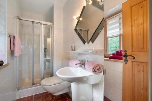 a bathroom with a sink and a shower and a toilet at Ferienwohnung Rauschberg in Ruhpolding