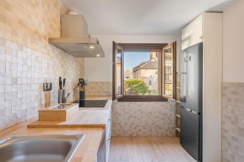 a kitchen with a sink and a large window at Carmen San Andrés in Granada