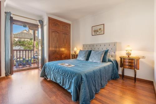 a bedroom with a bed with a blue blanket at Carmen San Andrés in Granada