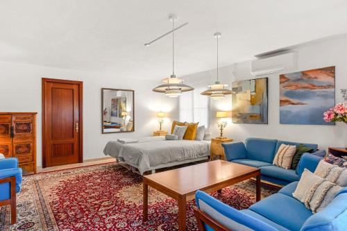 a bedroom with a bed and blue chairs and a table at Villa Cempo V215 in La Cala de Mijas