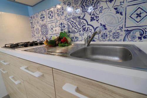 a kitchen with a sink and blue and white tiles at Casa Vacanze Nike a Otranto in Otranto