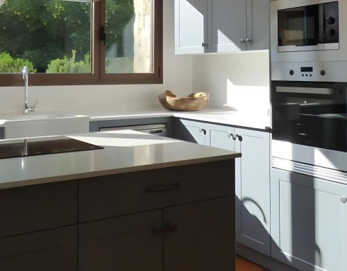 a kitchen with white cabinets and black appliances at Casa Rural Fuentebuena in Matabuena