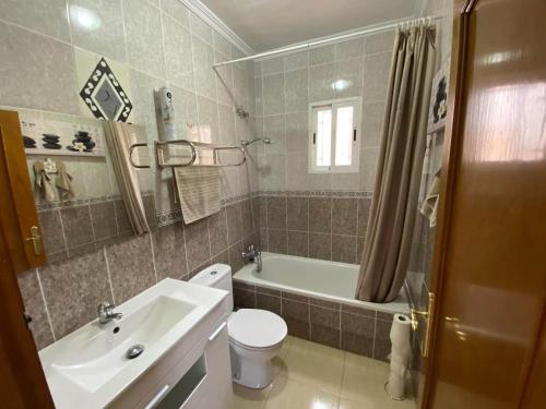 a bathroom with a sink and a toilet and a tub at Alberca La Nucia in Polop