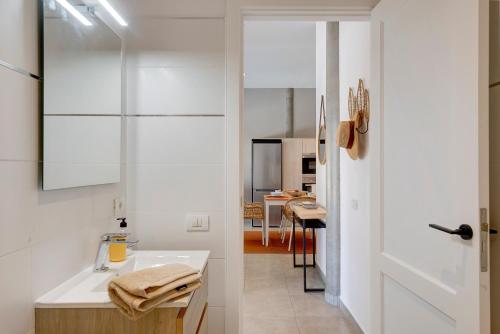 a white bathroom with a sink and a kitchen at Urban Park Girasol in Los Llanos de Aridane