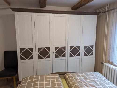 a bedroom with a bed and a large white cabinet at Ferienwohung Stelldichein in Altenbrak