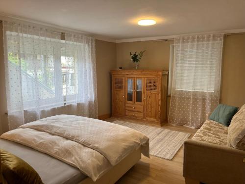 a bedroom with a bed and a window and a couch at Wohnung mit Dachterasse in Absberg