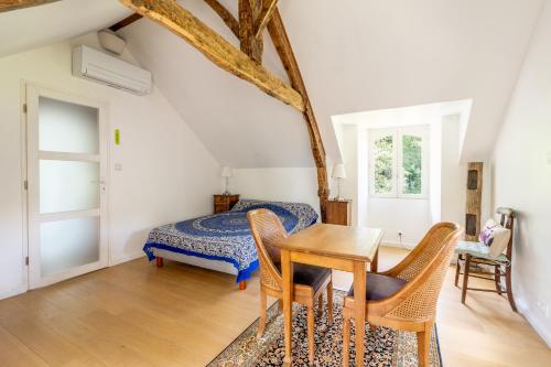a bedroom with a bed and a table and chairs at Chambre d'hôtes Kerdary in Nivillac