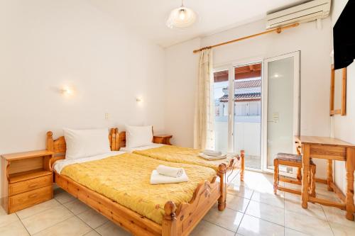 a bedroom with a large bed and a desk at Olivea Studio 3 in Acharavi