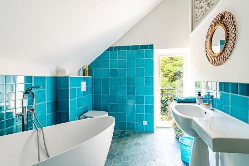 a blue bathroom with a tub and a sink at Chambre d'hôtes Kerdary in Nivillac