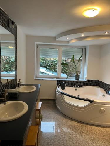 a large bathroom with two sinks and a tub at Wohnung mit Dachterasse in Absberg