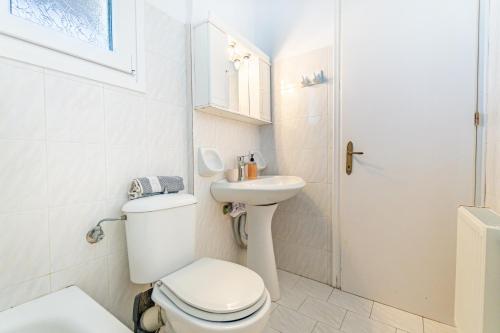 a white bathroom with a toilet and a sink at Olivea Studio 3 in Acharavi