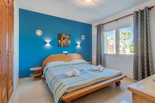 a blue bedroom with a bed and a window at Villa Cucarres in Calpe
