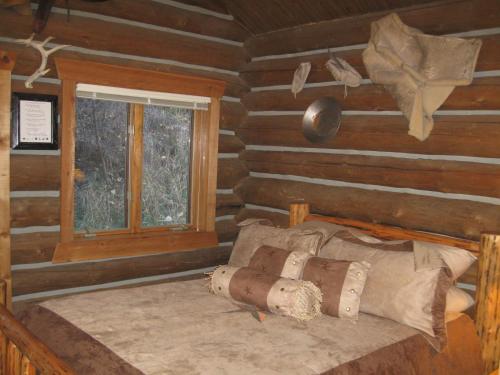 a bedroom with a bed in a log cabin at Rye Creek Lodge in Darby