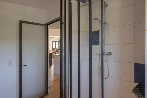 a bathroom with a shower and a glass door at Villa Luminières I in Sallelles