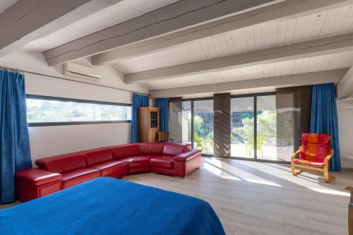 a living room with a red couch and a red chair at Villa Luminières I in Sallelles