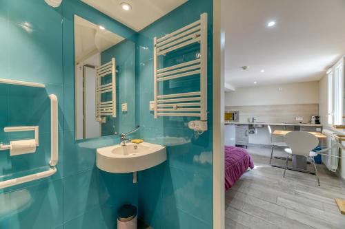 a bathroom with blue walls and a sink at Logis Les Forges in Arvillard