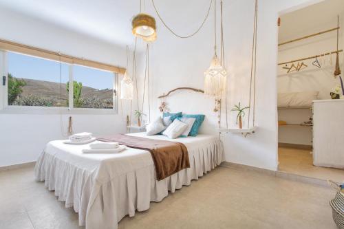 a white bedroom with a bed with a table at El Refugio de Churchill in Máguez