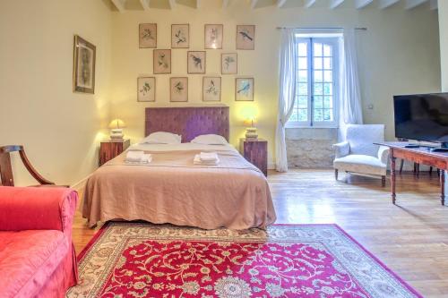 a bedroom with a bed and a tv and a couch at Le Bel Prat in Domme