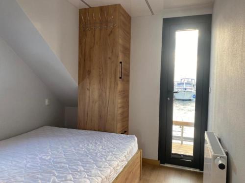 a bedroom with a bed and a door with a window at Führerscheinfreies mobiles Hausboot in Rechlin