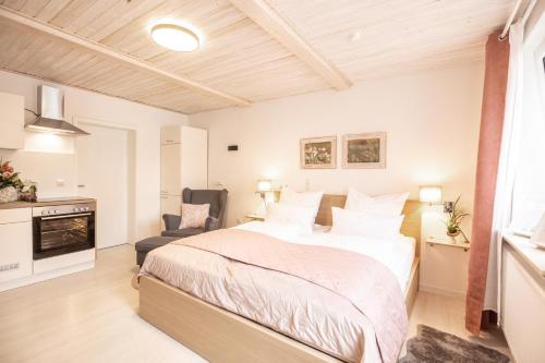 a bedroom with a large bed and a chair at Apartment Wasenberg in Willingshausen