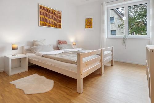 a white bedroom with a bed and a window at Auszeit am Wiehengebirge in Bad Essen
