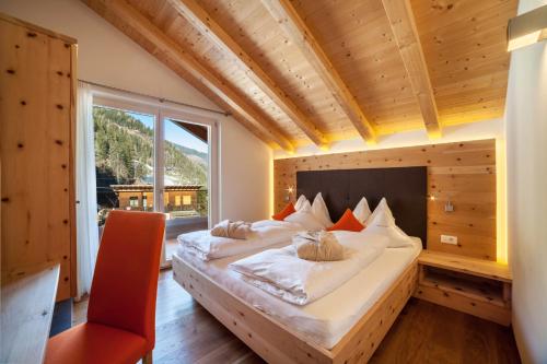 a large bed in a room with a large window at Chalet de Ultimis in Ultimo