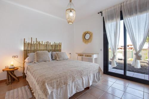 a bedroom with a bed and a large window at Sunny Home in Lajares