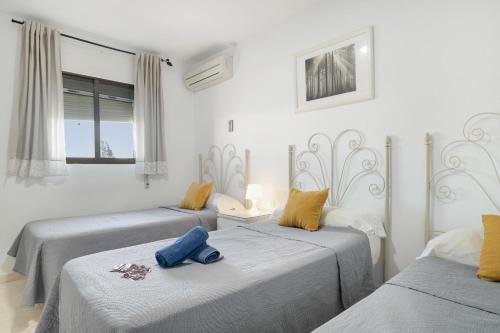 a room with two beds with towels on them at Hostal Avenida in Conil de la Frontera