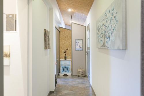 a hallway with white walls and a blue and white painting on the wall at Sobreirinho - Selão da Eira in São Teotónio