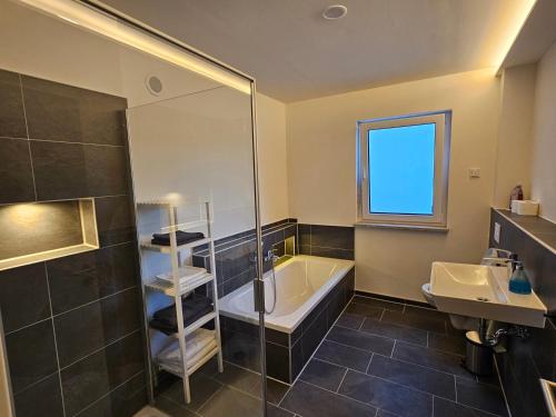 a bathroom with a tub and a sink at Ferienwohnung Auszeit in Solnhofen
