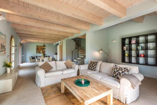 a living room with white couches and a wooden ceiling at Chalet Azzurro in Trequanda