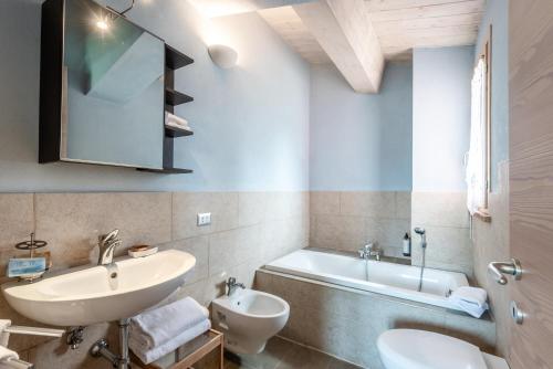 a bathroom with a sink and a toilet and a tub at Chalet Azzurro in Trequanda