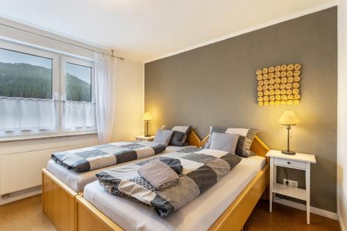 two beds in a bedroom with a large window at Ferienwohnung Richter in Kirchhundem
