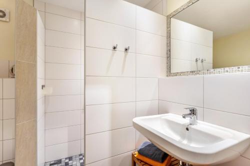 a white bathroom with a sink and a mirror at Ferienwohnung Richter in Kirchhundem