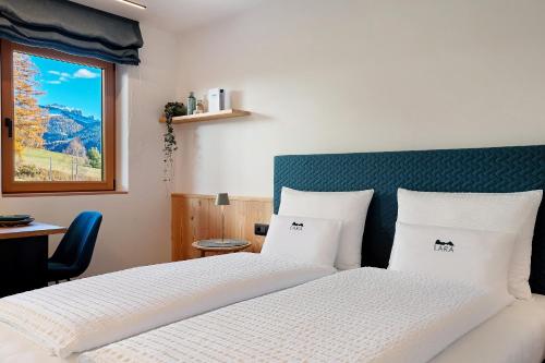 a bedroom with a bed with white sheets and a window at Apt Lara Ruveda 2 in Ortisei