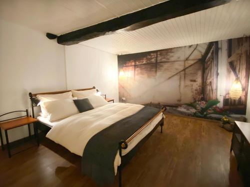 a bedroom with a large bed with a painting on the wall at Haus Auenland in Groß Felda
