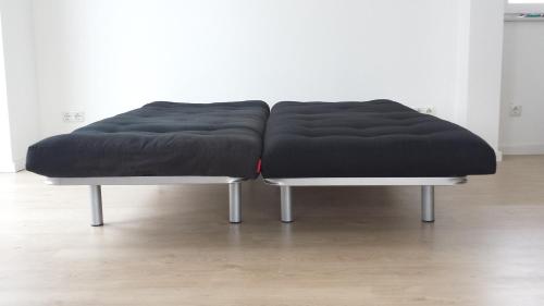a large black bean bag chair on two metal legs at Ferienwohnung Birkenhof Alfsee in Rieste
