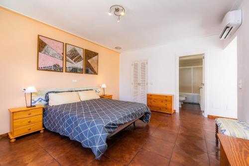 a bedroom with a bed and a wooden floor at Villa Paca in Cala Ratjada