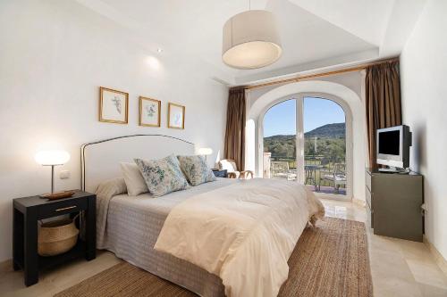 a bedroom with a bed and a large window at Arcos golf Adosado 2 dormitorios in Arcos de la Frontera