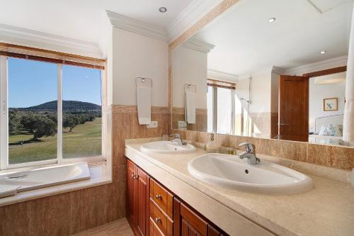 a bathroom with two sinks and a large window at Arcos golf Adosado 2 dormitorios in Arcos de la Frontera
