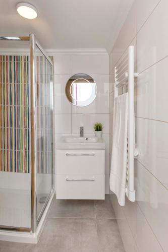 a white bathroom with a sink and a shower at Villa Petala in Albufeira