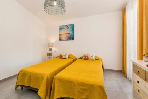 a bedroom with two beds with yellow sheets at Villa Petala in Albufeira