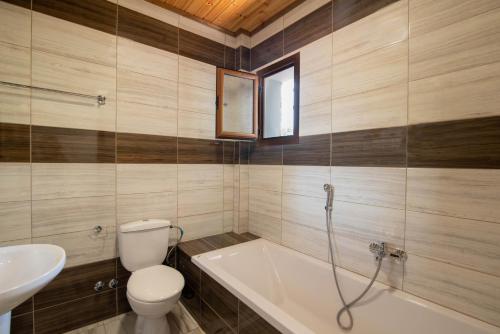 a bathroom with a tub and a toilet and a sink at Mirage Arillas Apartment C in Arillas
