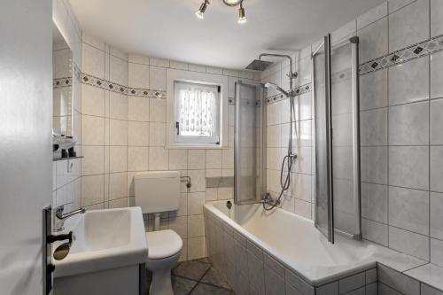 a bathroom with a tub and a toilet and a sink at Ferienwohnung Ankerplatz, 65qm in Sundern