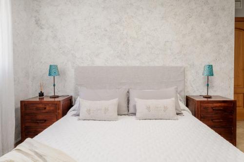 a bedroom with a white bed with two night stands at Legado Marino in Santa Pola