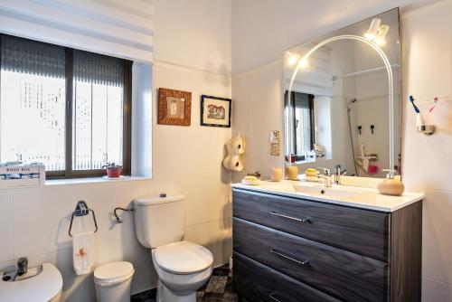 a bathroom with a sink toilet and a mirror at Casa Calle Ancha in Barbate